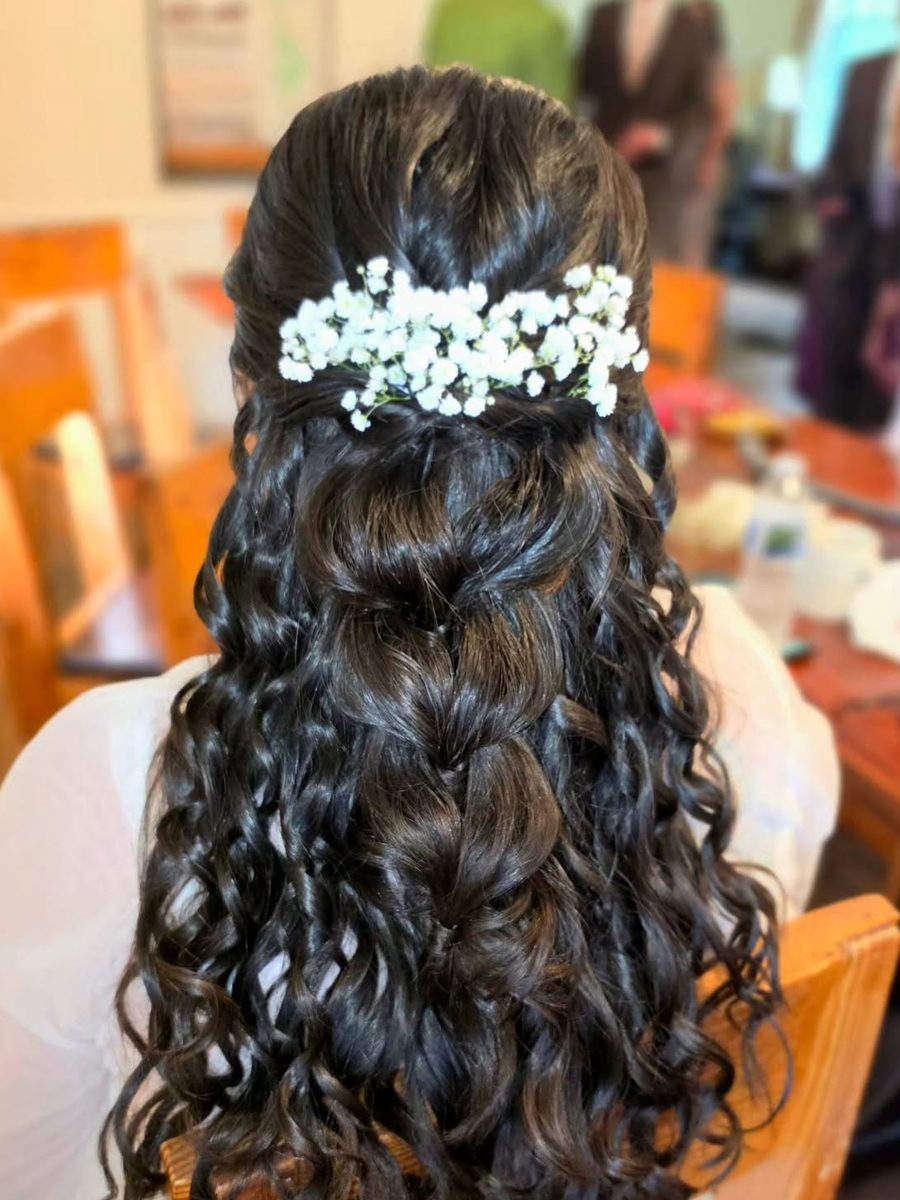 Dark curly half-up style finished with baby's breath