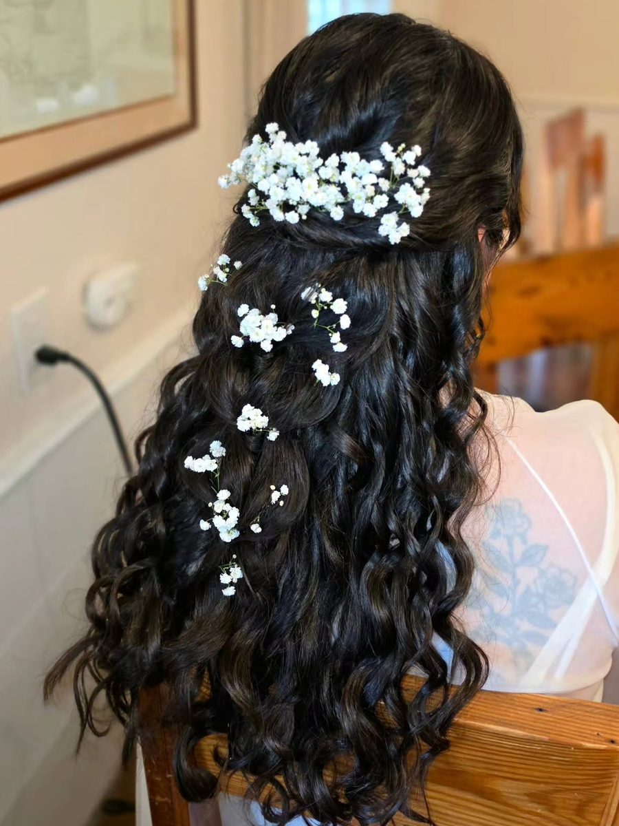 Long dark curls with baby's breath scattered through the hair